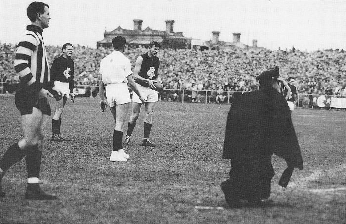 Collingwood vs Carlton - round 8, 1960. A policeman retrieves a beer bottle thrown from the crowd after Carlton's Graham Donaldson was awarded a free-kick deep in the Blues' forward line.